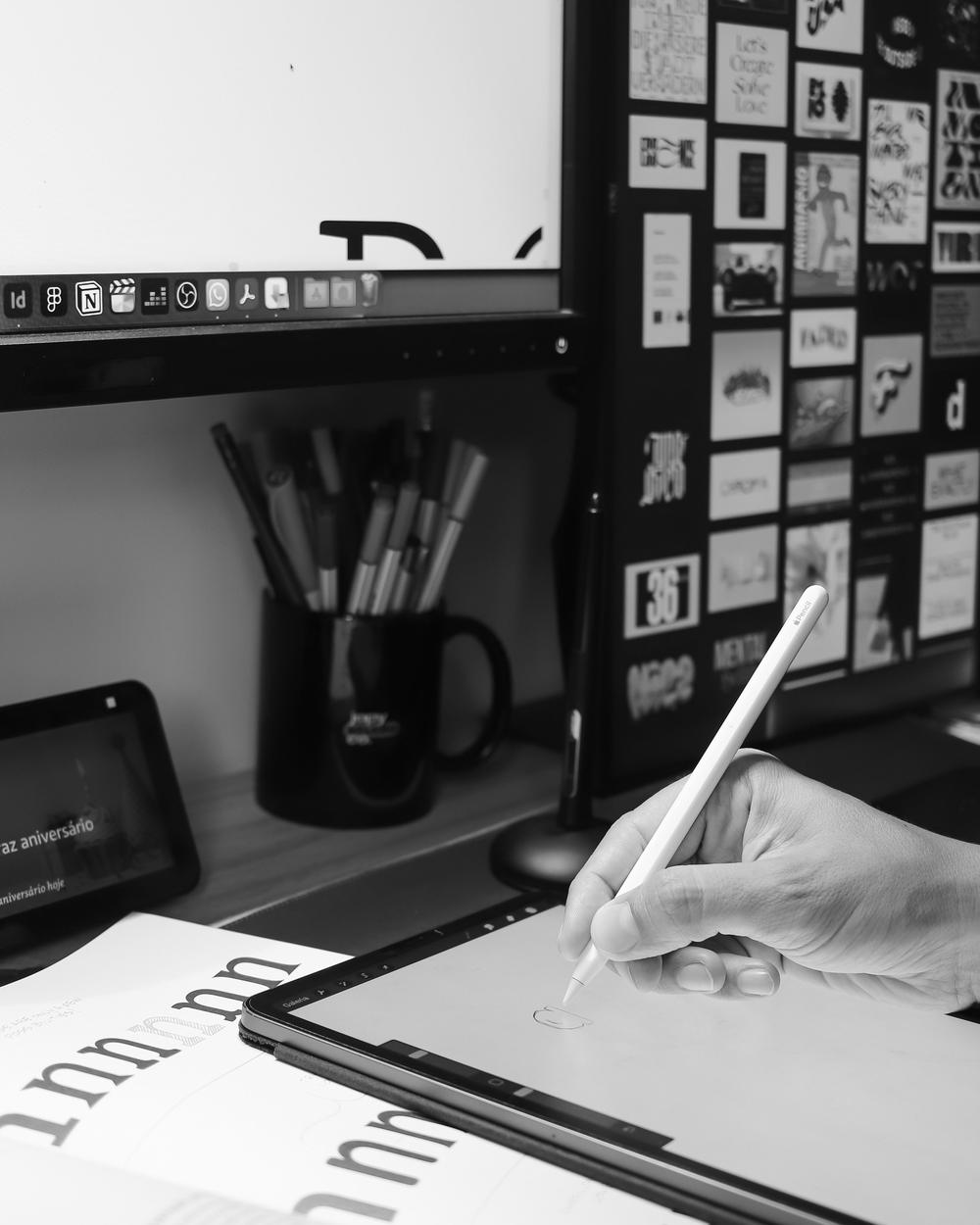 Mano dibujando en una tableta junto a un muro de inspiración